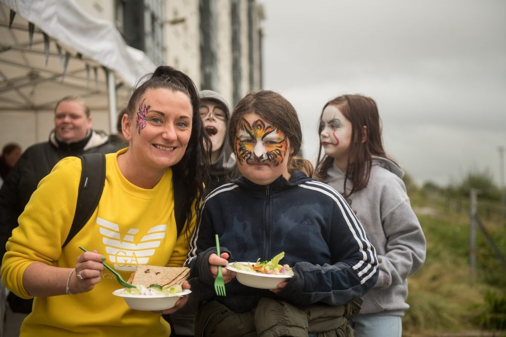 Photograph of members of the Cardonald community (child with face-paint and woman, with children in background) at Halfway Community Park at Moss Height Avenue, to celebrate its opening.