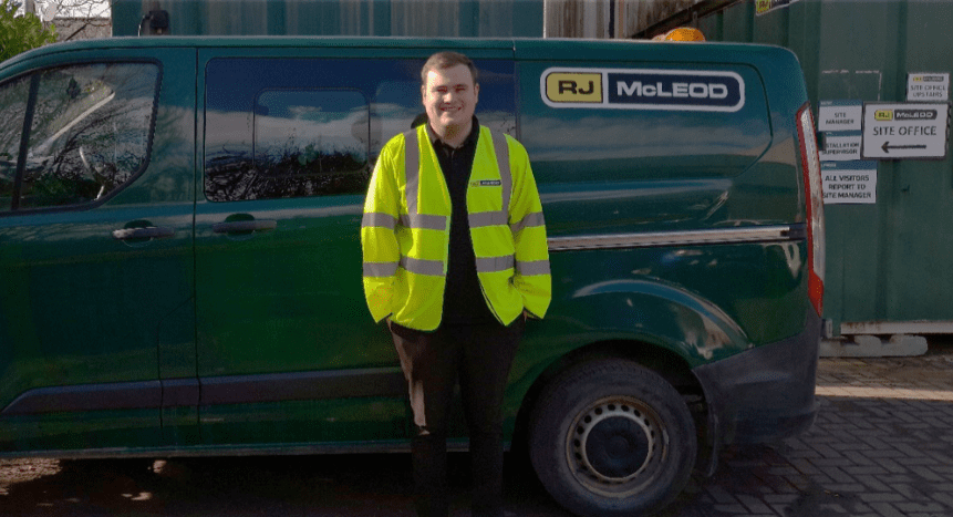 Apprentice william lloyd in front of an R.J.McLeod van in their plant yard.