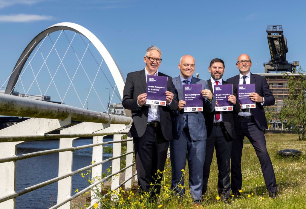Kevin Rush, Ross Nimmo, James McSporran and Peter Stirling standing in front of the Clyde Arc holding the Clyde Green Freeport bid.