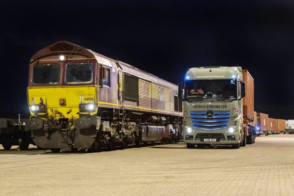 Image at Mossend International Railfreight Park - a train with a truck both facing the camera.