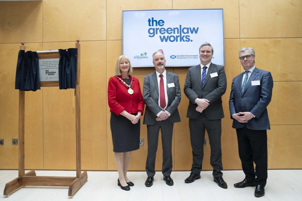 Photograph of The Greenlaw Works official opening plaque on the left, and standing on the right - from left to right and facing the camera, smiling - Provost Mary Montague, Council Leader Owen O'Donnell, Tom Arthur MSP, and Lord Offord of Garvel.