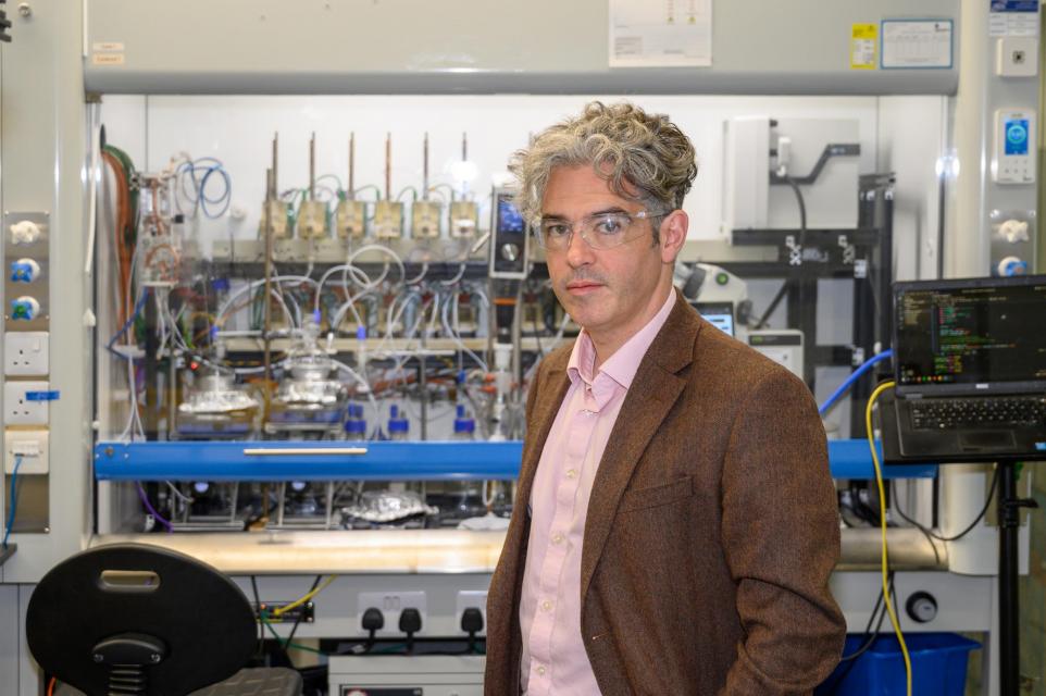 Professor Lee Cronin, CEO and co-founder of Chemify, standing in front of various lab equipment.