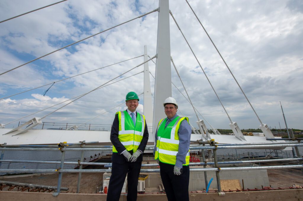 Lord Cameron and the Renfrewshire Council Leader standing in front of the first section of the bridge.